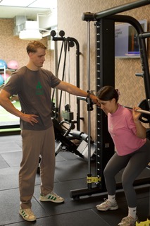 Client receiving guidance during a squat